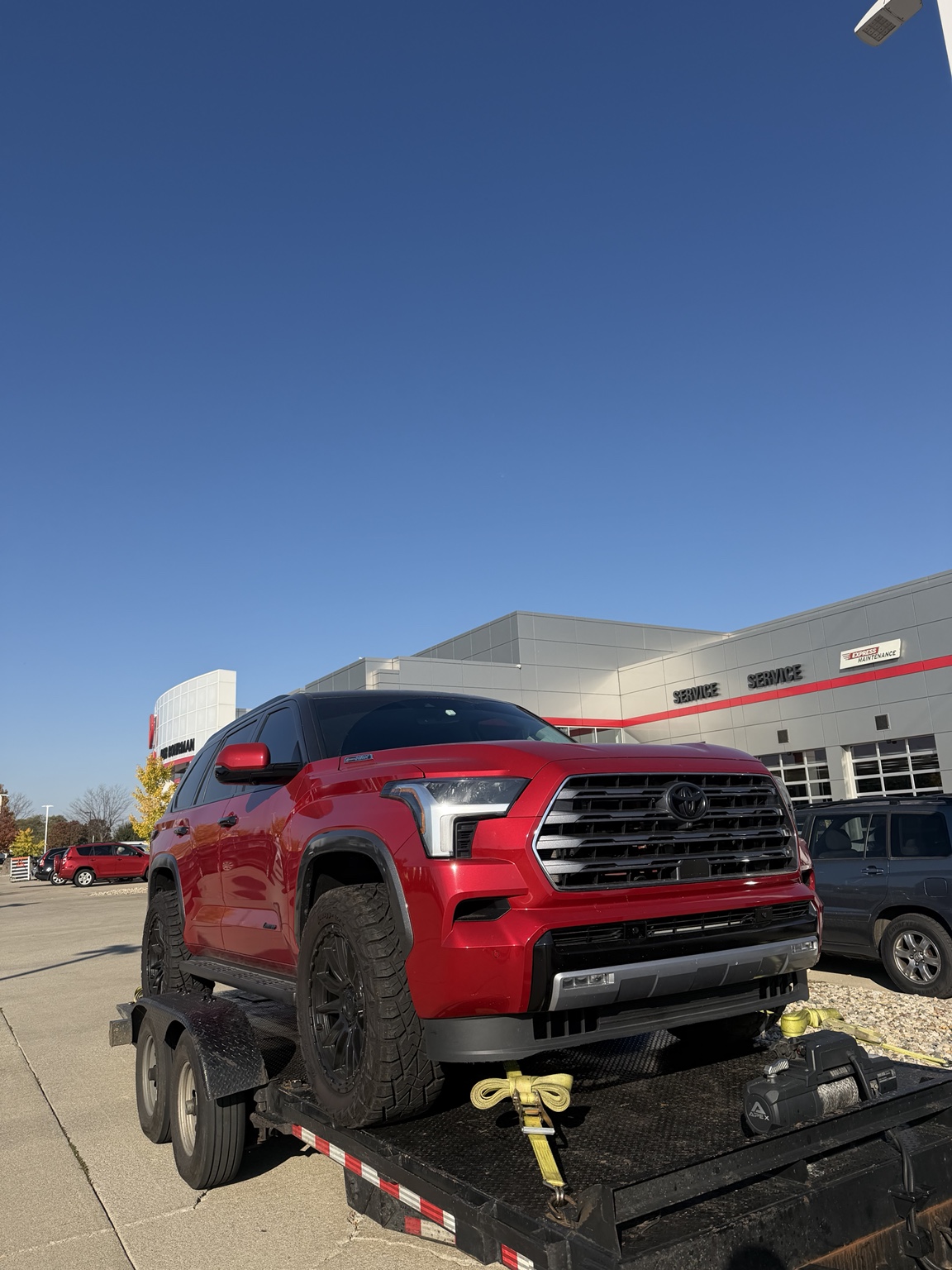 Red Toyota SUV secured on a vehicle transport trailer
